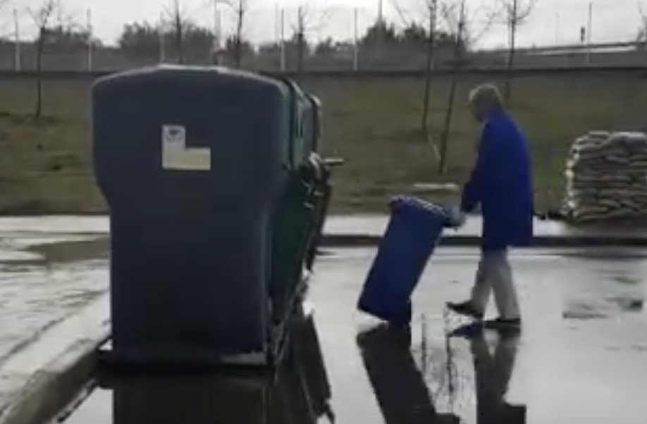 Operador levando o lixo até a área de lixo urbano do hospital